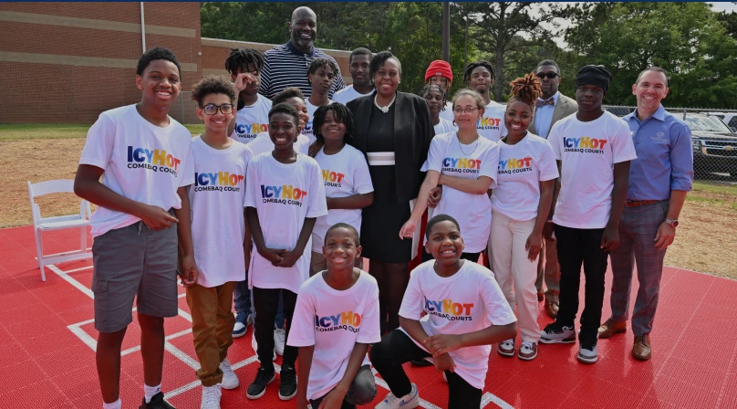 Shaquille O'Neil and a group of people (mostly young boys and girls) standing on the Henry County Comebaq Court.